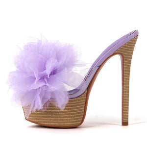 High-heeled shoe with a large purple flower on a white background