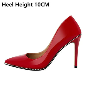 Red high-heeled shoe with studded details on a white background