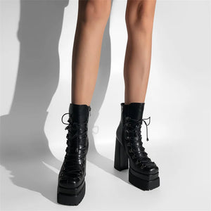Black platform boots worn by a person on a white background