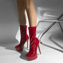 Load image into Gallery viewer, Red high-heeled boots worn by a person on a gray background