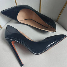 Load image into Gallery viewer, Navy blue high-heeled shoes with studded details on a light gray background