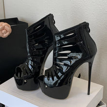 Load image into Gallery viewer, Black high-heeled shoes with cut-out design on a white surface.