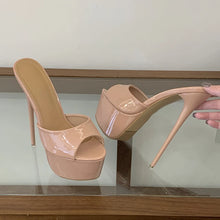 Load image into Gallery viewer, Beige high-heeled shoes on a clear stand with a hand holding one shoe.