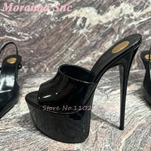 Load image into Gallery viewer, A black patent leather high-heeled mule sandal with a chunky platform and stiletto heel, displayed on a gray marble-patterned surface.