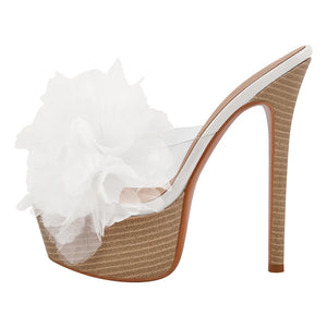 High-heeled shoe with white floral detail on a white background