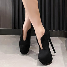 Load image into Gallery viewer, Black high-heeled shoes worn by a person on a neutral background