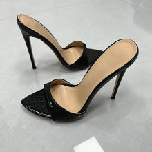 Load image into Gallery viewer, A pair of black patent leather slingback high heels with pointed toes and a subtle crocodile-embossed pattern on the toe strap, shown on a light gray floor.