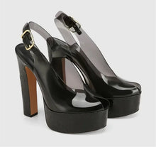 Load image into Gallery viewer, Black platform high heels with a gold buckle on a light gray background