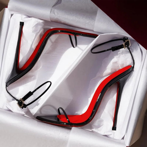 Black and red high-heeled shoes in a white box