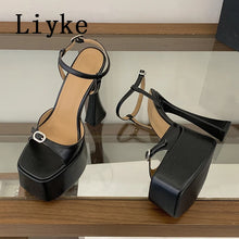 Load image into Gallery viewer, Black high-heeled shoes with platform on a reflective surface, brand 'Liyke' visible.