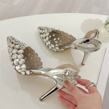 Load image into Gallery viewer, Silver high-heeled shoes with crystal embellishments on a white surface.