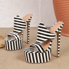 Load image into Gallery viewer, A pair of women's high-heeled mule sandals with bold black and white vertical stripes, featuring a cutout peep toe, a chunky platform sole, and a slim stiletto heel, displayed on a textured beige surface.