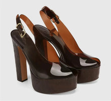 Load image into Gallery viewer, Pair of brown high-heeled platform shoes on a light gray background