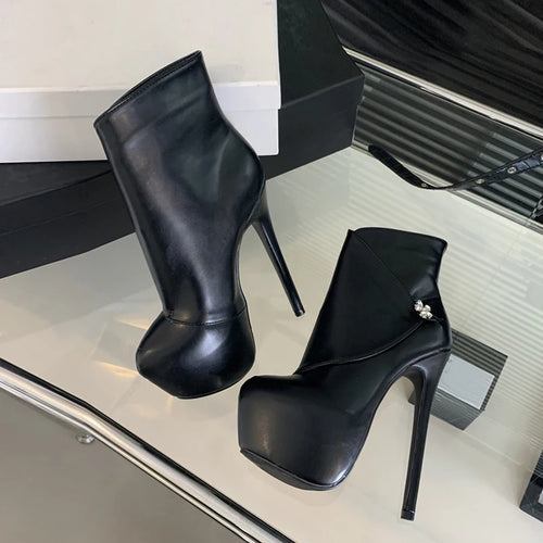 Black high-heeled boots on a reflective surface with a blurred background