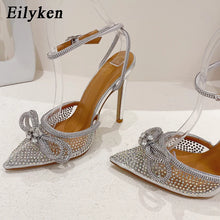 Load image into Gallery viewer, Silver high-heeled shoes with rhinestone details on a white background, featuring the brand &#39;Eilyken&#39;.