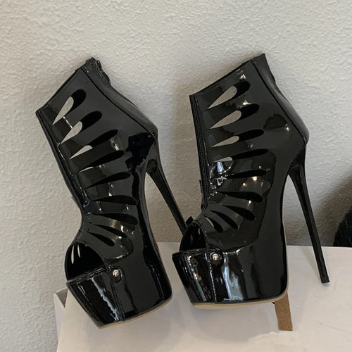 Black high-heeled shoes with cut-out design on a white surface.