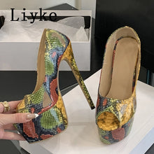Load image into Gallery viewer, A pair of high-heeled platform pumps with a multicolor snakeskin pattern, held by a hand on a white surface with a shoebox in the background. The brand name 'Liyo' is visible in the top left corner.