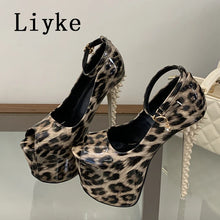 Load image into Gallery viewer, A pair of high-heeled platform sandals with a leopard print pattern, featuring ankle straps and spiked heels, displayed on a glass surface with a white quilted handbag in the background.