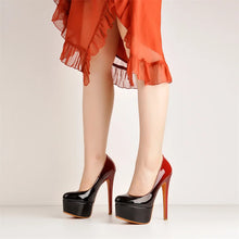 Load image into Gallery viewer, A person wearing glossy black platform high heels with red stiletto heels and a sheer orange ruffled dress, shown from the knees down against a plain light background.