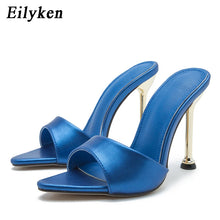 Load image into Gallery viewer, Blue high-heeled sandals with gold metallic heel on a white background, branded 'Eilyken'.