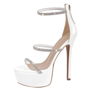 White high-heeled shoe with silver straps on a white background