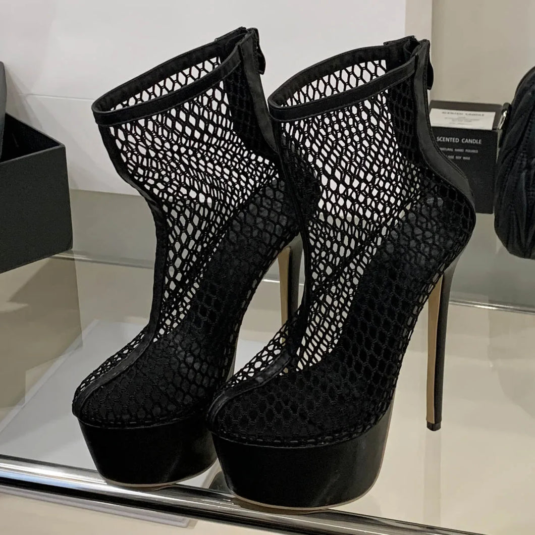 Black fishnet high-heeled shoes on a reflective surface