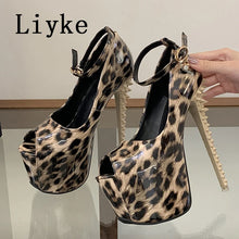 Load image into Gallery viewer, A pair of high-heeled platform sandals with a glossy leopard print pattern, shown on a reflective surface with a hand holding one shoe. The brand name 'Liyke' is printed in the top left corner.