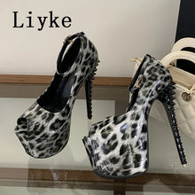 Load image into Gallery viewer, A pair of high-heeled platform sandals with a glossy black and white leopard print, featuring spiked stiletto heels and ankle straps. The brand name 'Liyke' is printed in black in the top left corner.