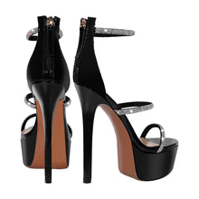Load image into Gallery viewer, Black high-heeled platform shoes with decorative straps on a white background