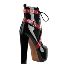 Load image into Gallery viewer, Black patent leather boot with red straps on a white background