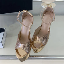 Load image into Gallery viewer, Gold high-heeled shoes on a reflective surface