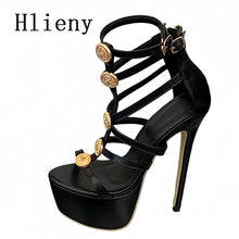 Load image into Gallery viewer, A single black strappy high-heeled sandal with gold-tone decorative coin embellishments on the straps, shown on a plain white background with the brand name 'Hlieny' in the top left corner.