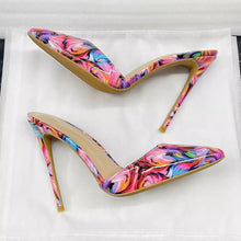 Load image into Gallery viewer, A pair of pointed-toe stiletto pumps with a vibrant, multicolored swirl marble pattern in pink, blue, purple, and orange, featuring tan soles, displayed on a white background.