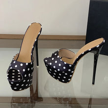 Load image into Gallery viewer, Black high-heeled shoes with white polka dots on a reflective surface.