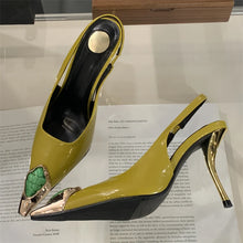 Load image into Gallery viewer, Yellow high-heeled shoes with gold accents on a book