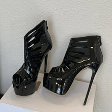 Load image into Gallery viewer, Black high-heeled shoes with platform on a white surface against a light gray wall.