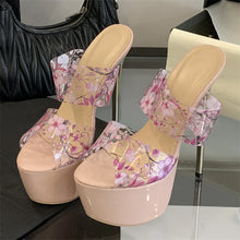 Load image into Gallery viewer, Beige high-heeled shoes with floral design on a reflective surface.