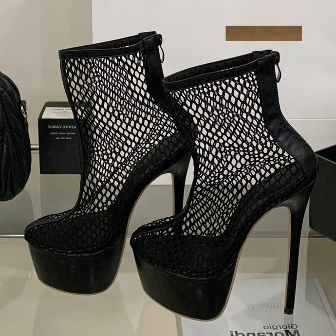 Black mesh platform high-heeled shoes on a reflective surface with a blurred background.