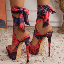 Load image into Gallery viewer, Colorful high-heeled shoes with floral patterns on a patterned floor.