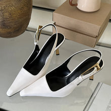 Load image into Gallery viewer, White and black pointed-toe slingback heels with gold accents on a reflective surface.