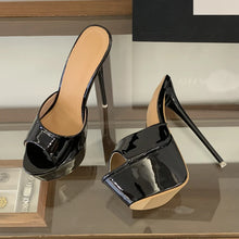 Load image into Gallery viewer, Black high-heeled shoes with open-toe design on a reflective surface.