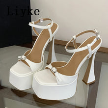 Load image into Gallery viewer, White high-heeled sandals with decorative straps on a reflective surface, branded 'Liyke'.