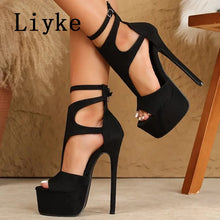Load image into Gallery viewer, Black high-heeled platform shoes with cut-out design worn by a person, on a neutral background.
