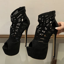 Load image into Gallery viewer, Black high-heeled platform shoes with cut-out design on a reflective surface.