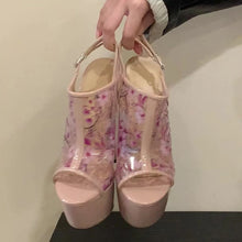 Load image into Gallery viewer, Pink floral high-heeled shoes held by a hand against a neutral background