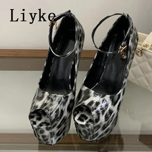 Load image into Gallery viewer, A pair of high-heeled platform shoes with a black and white leopard print pattern, featuring ankle straps and gold-tone hardware. The brand name 'Liyke' is printed in black text in the upper left corner.