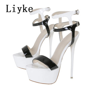 White high-heeled sandals with black patent leather straps on a white background, featuring the brand 'Liyke'.