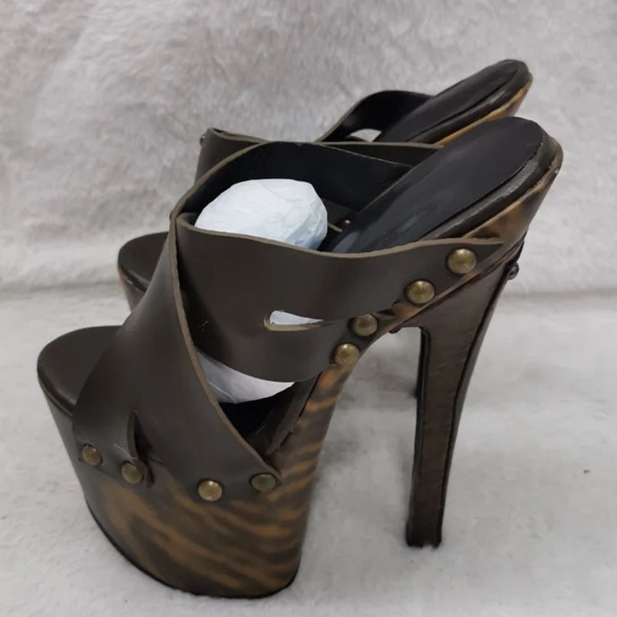 Brown high-heeled sandal with studded details on a light gray background